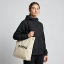 Woman holding EMBA tote bag